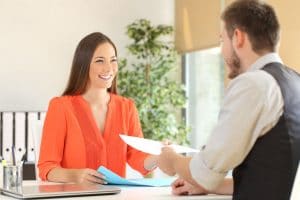 71158793 - woman giving a resume to the interviewer in a job interview