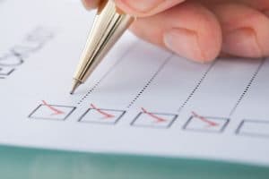 29529383 - cropped image of businessman preparing checklist at office desk